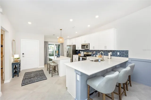 a kitchen with kitchen island granite countertop a sink a stove and a wooden floors