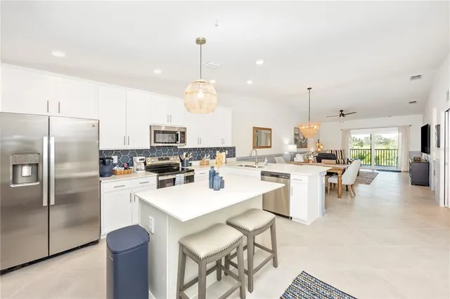 a kitchen with a refrigerator a sink a stove and cabinets
