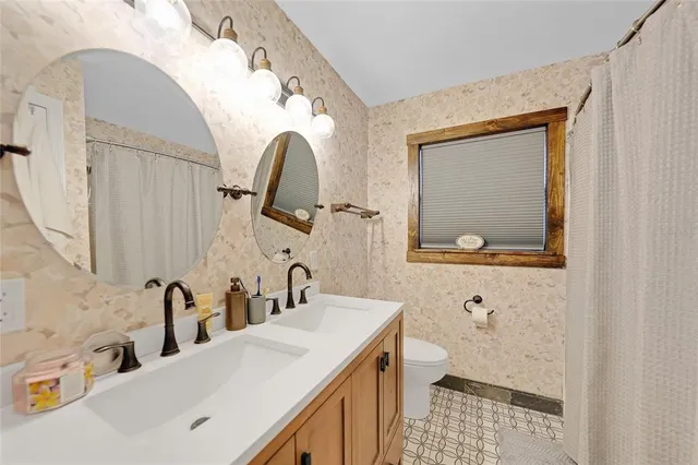 a bathroom with a sink a toilet and a mirror