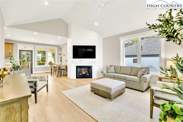 a living room with furniture a fireplace and a flat screen tv