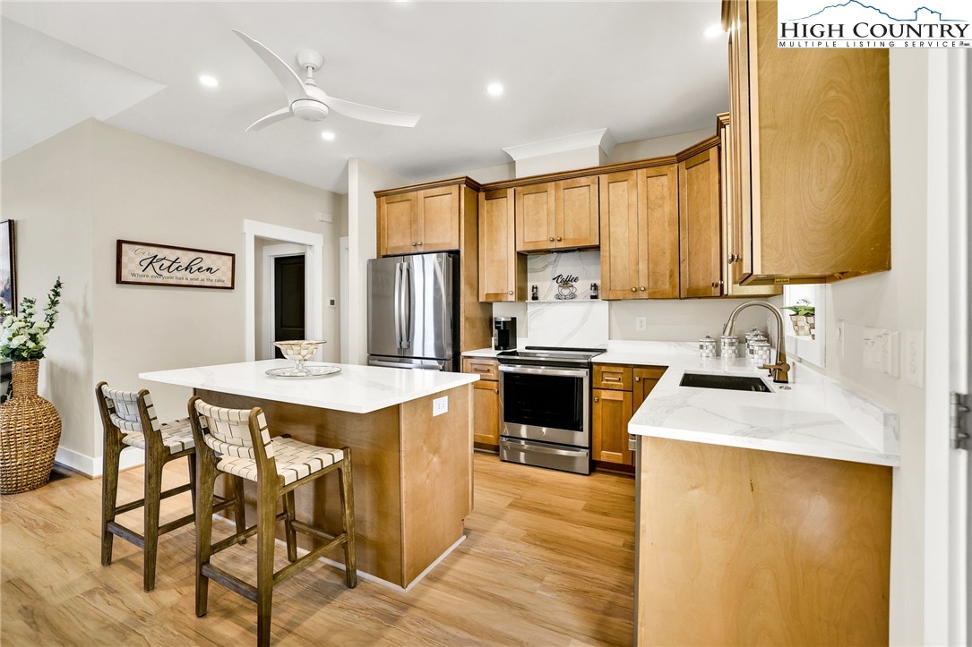379 Turtle Rdg Road Sparta, NC 28675 - Photo 19 of 43 a kitchen with a refrigerator a stove a sink dishwasher and white cabinets with wooden floor