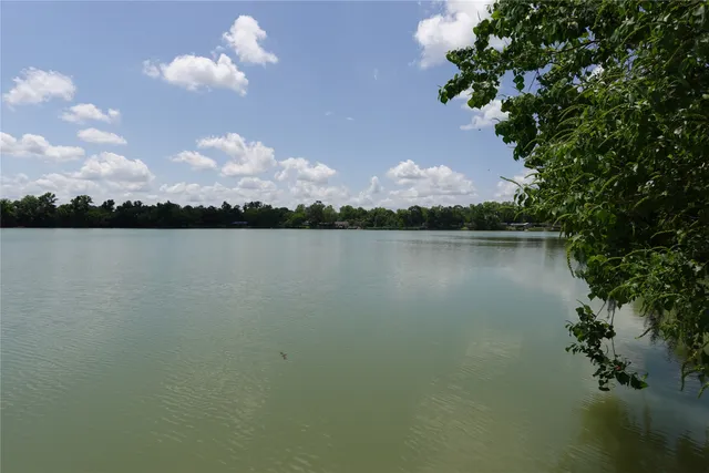 a view of a lake with a bench and trees