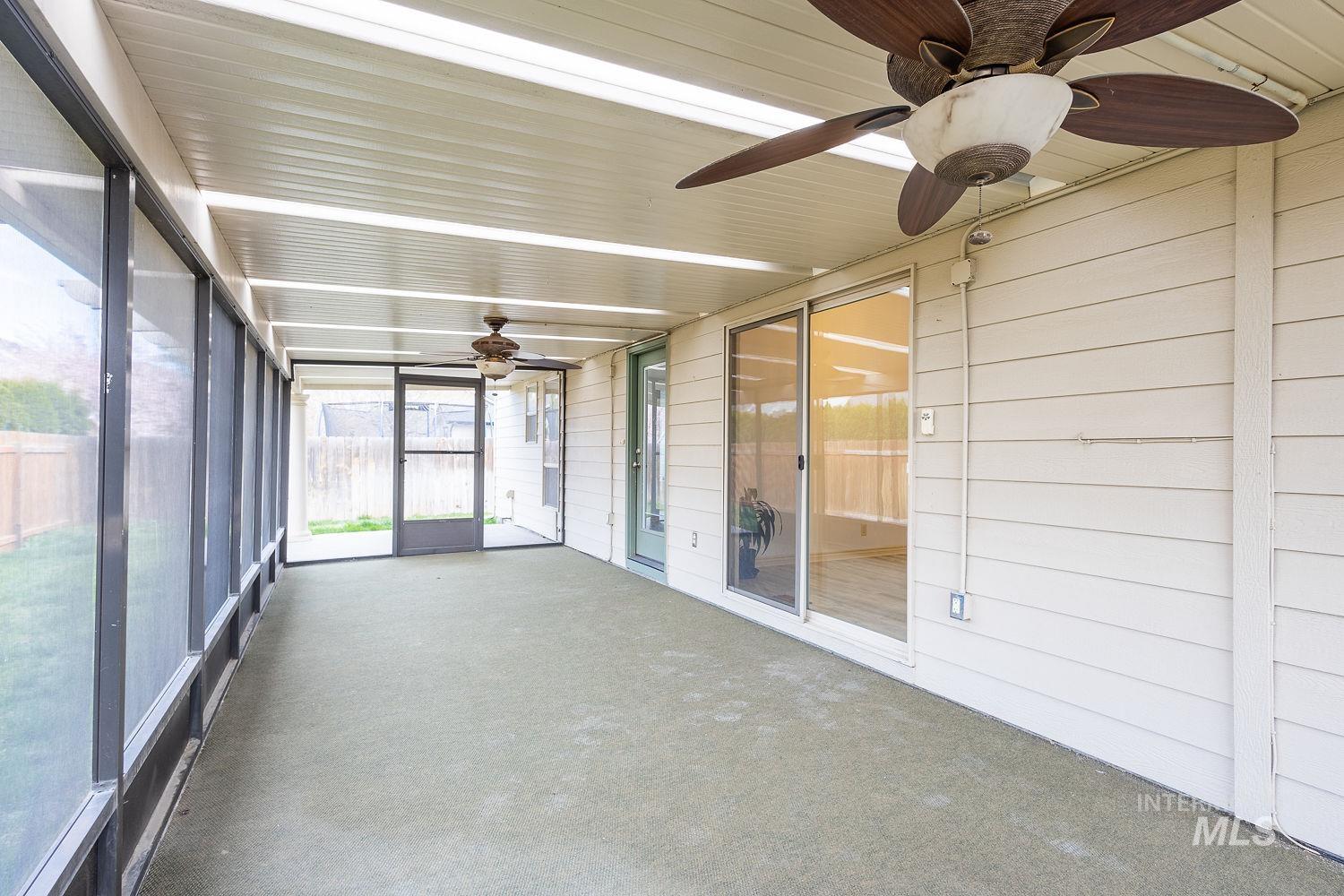 4227 North Rhodes Avenue Meridian, ID 83646 - Photo 24 of 27 Expansive screened porch featuring a covered ceiling with integrated lighting, two ceiling fans, exterior siding, and a sliding glass door for interior access