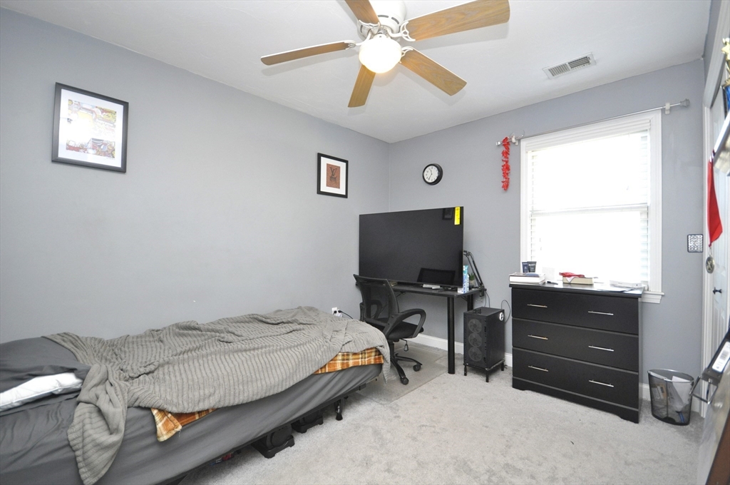 413 Harvard Street Whitman, MA 02382 - Photo 25 of 42 a bedroom with a bed and flat screen tv