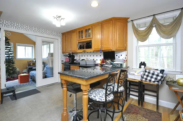 a kitchen with a dining table chairs and a refrigerator