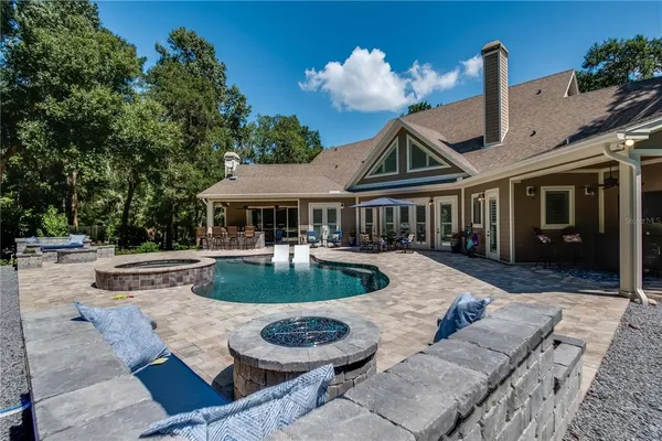a view of a house with backyard and sitting area