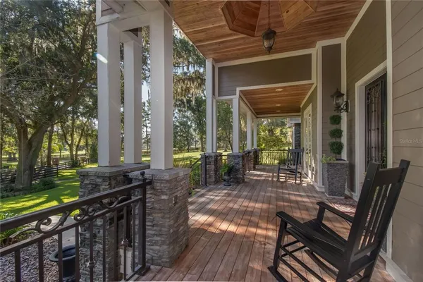 a kitchen with granite countertop kitchen island stainless steel appliances a table chairs sink and wooden floor