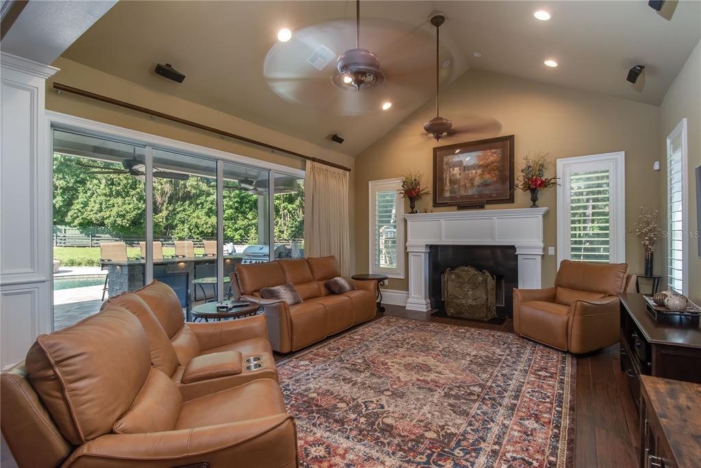 1219 Southwest 63rd Street Road Ocala, FL 34476 - Photo 32 of 72 a living room with furniture a large window and a fireplace