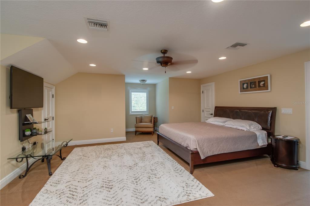 1219 Southwest 63rd Street Road Ocala, FL 34476 - Photo 57 of 72 a spacious bedroom with a bed and a flat screen tv