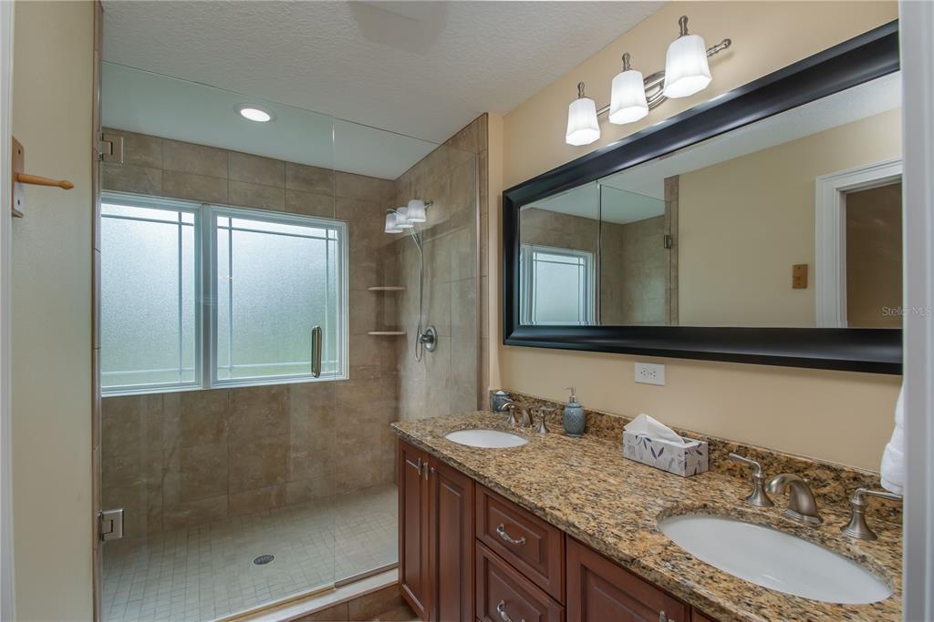 1219 Southwest 63rd Street Road Ocala, FL 34476 - Photo 58 of 72 a bathroom with a granite countertop sink mirror and double