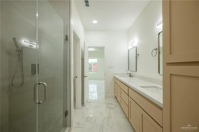 a bathroom with a granite countertop sink mirror and a shower