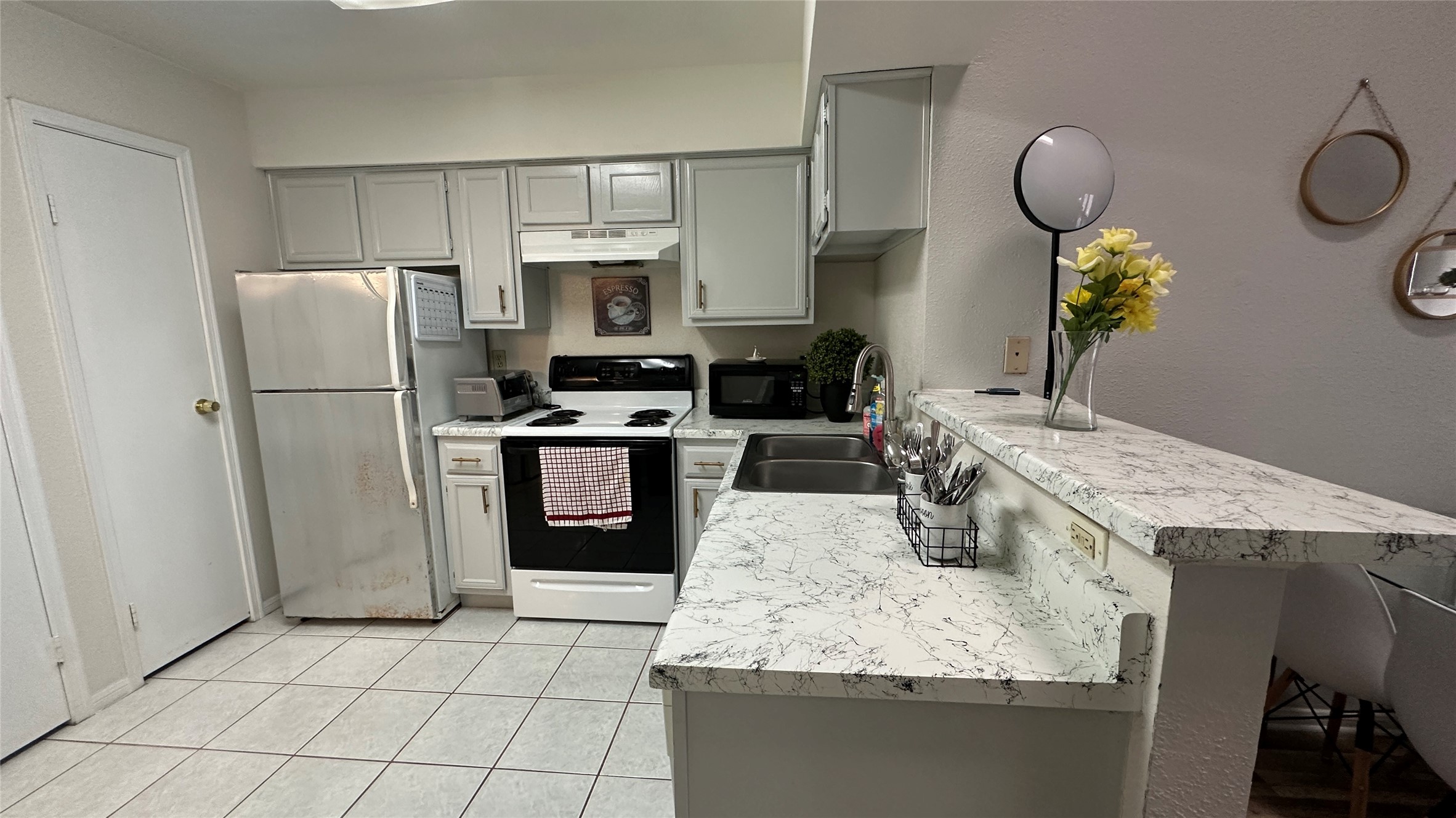 2425 Holly Hall Street, Unit 51C Houston, TX 77054 - Photo 4 of 10 a kitchen with a sink a refrigerator a stove a washer and dryer