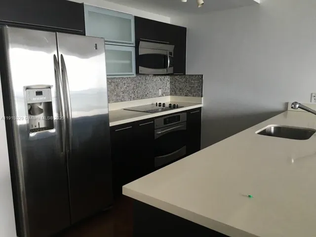 a kitchen with a refrigerator and a sink