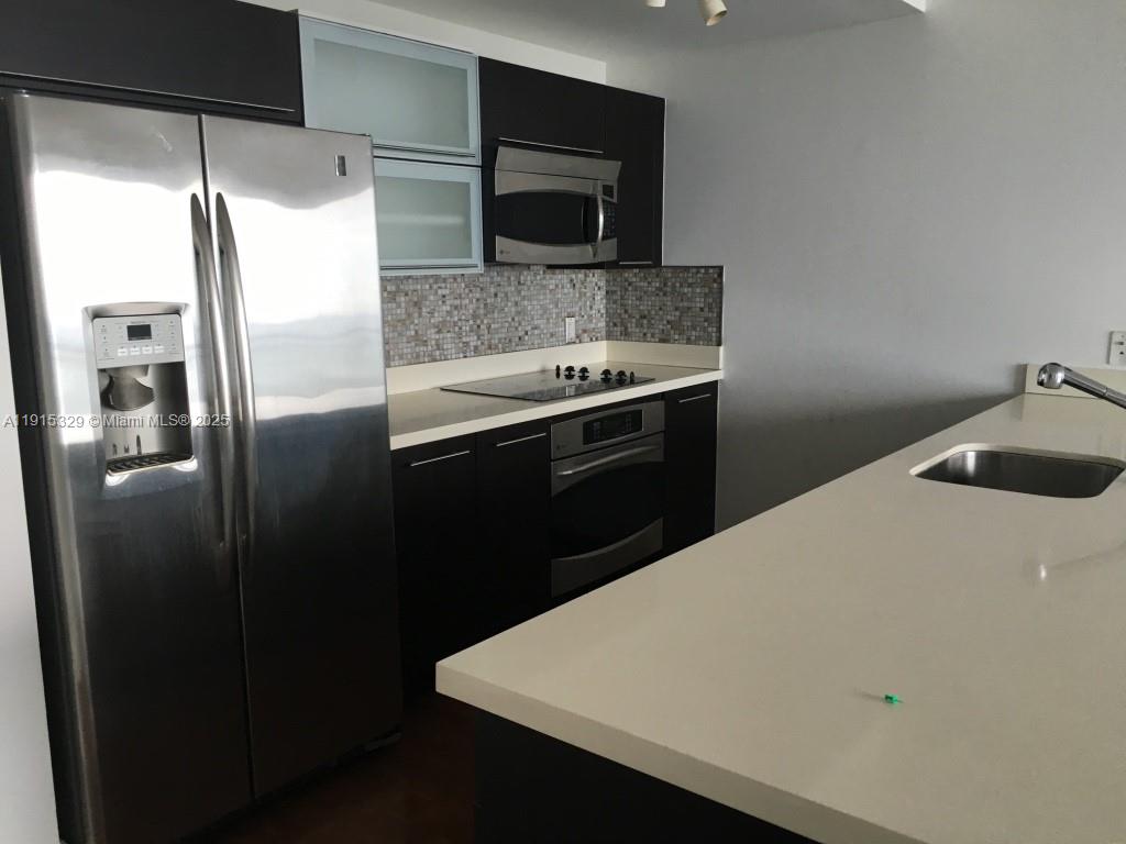 90 Southwest 3rd Street, Unit 3608 Miami, FL 33130 - Photo 2 of 12 a kitchen with a refrigerator and a sink