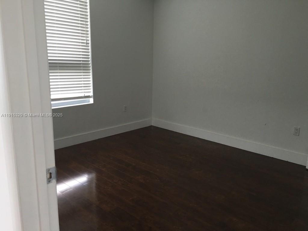 90 Southwest 3rd Street, Unit 3608 Miami, FL 33130 - Photo 8 of 12 a view of an empty room with wooden floor and a window
