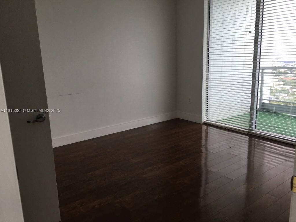 90 Southwest 3rd Street, Unit 3608 Miami, FL 33130 - Photo 9 of 12 an empty room with wooden floor and windows
