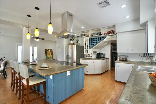 a view of kitchen island with stainless steel appliances sink refrigerator dining table and chairs