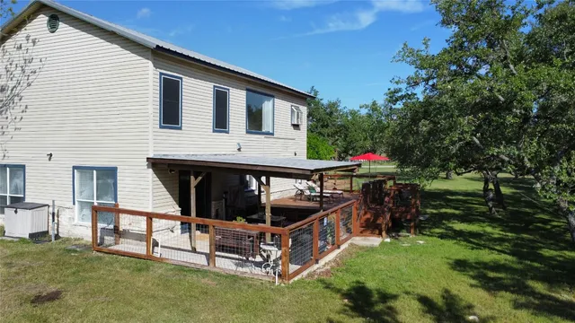 a view of patio with table and chairs and couches with wooden floor and fence