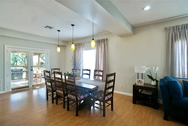 a dining room with furniture a chandelier and wooden floor