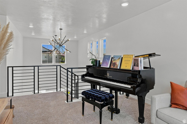 355 West 3085 South Logan, UT 84321 - Photo 20 of 40 Modern chandelier fixture, recessed lighting, white walls, black horizontal bar railing, and carpeted flooring