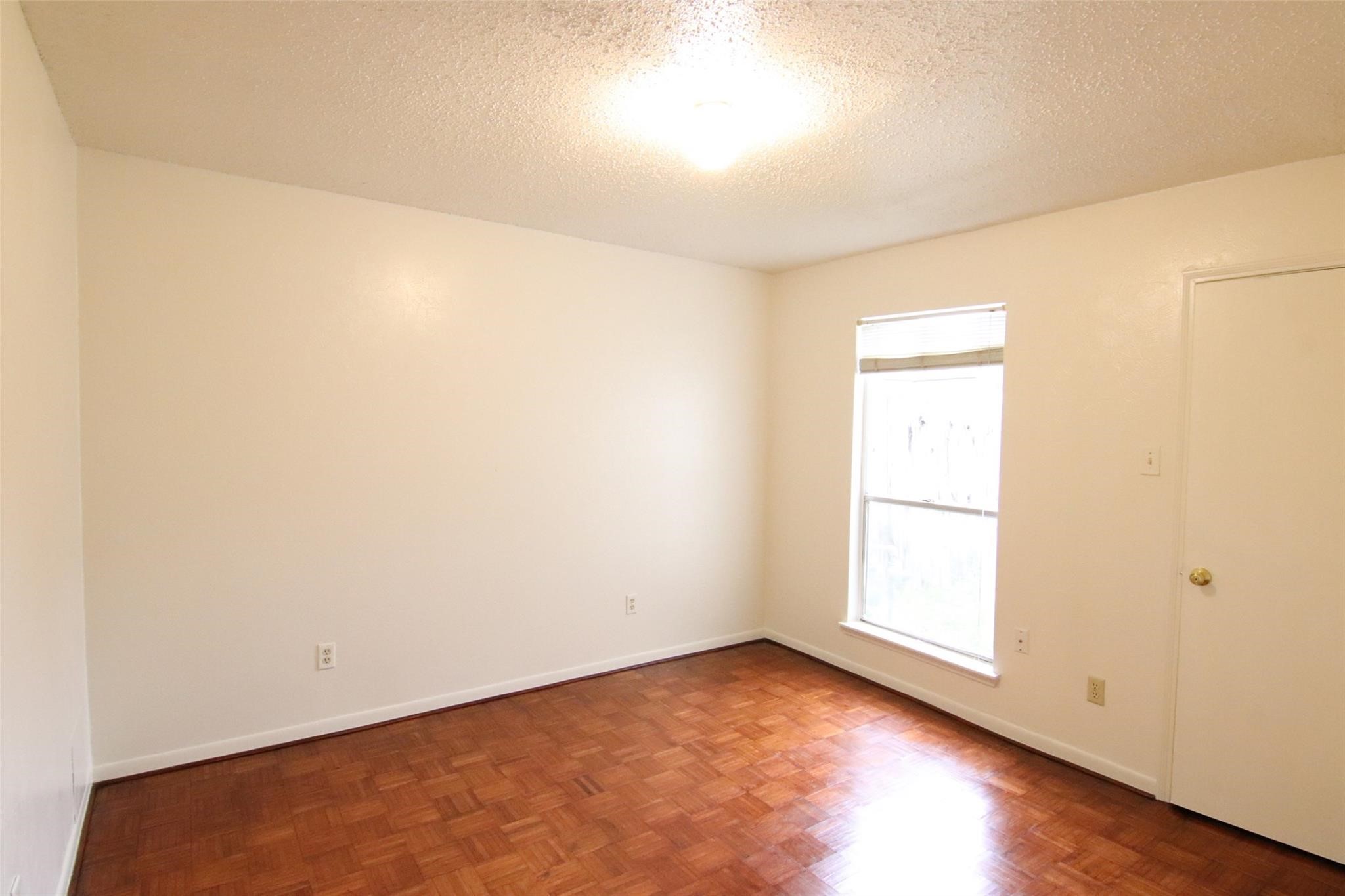 4231 Yupon Ridge Drive Houston, TX 77072 - Photo 13 of 18 an empty room with wooden floor and windows