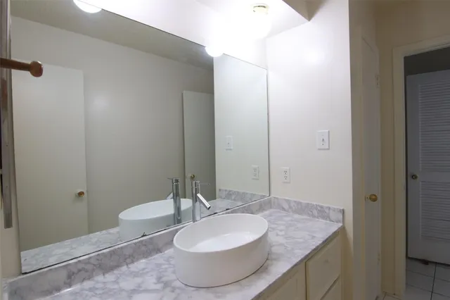 a bathroom with a granite countertop sink and a mirror