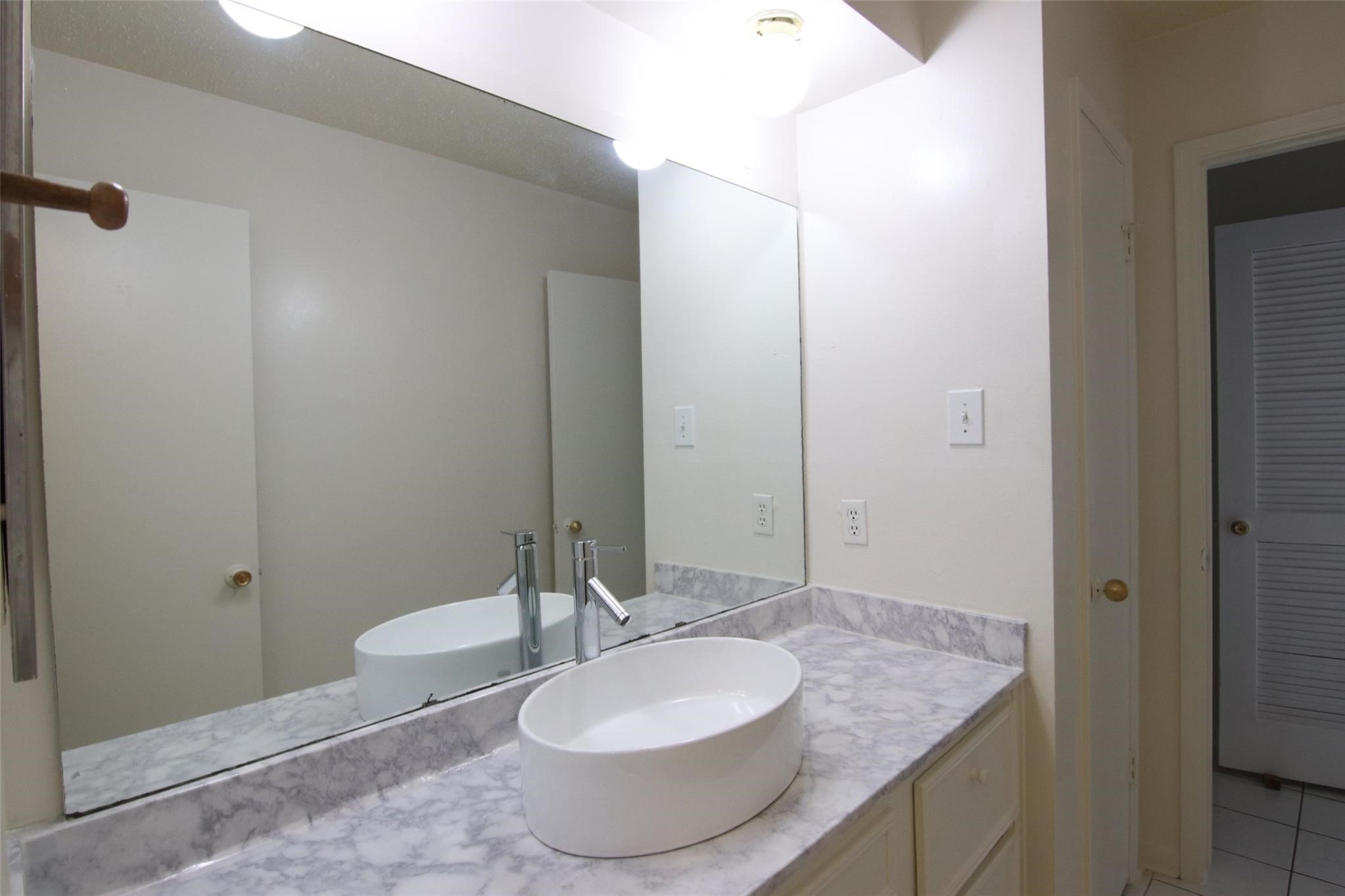 4231 Yupon Ridge Drive Houston, TX 77072 - Photo 16 of 18 a bathroom with a granite countertop sink and a mirror