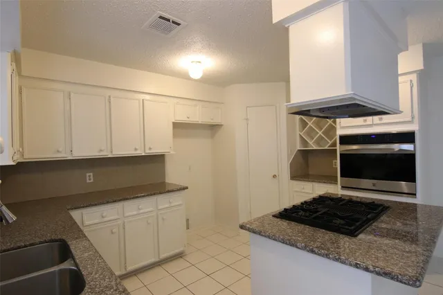 a kitchen with white cabinets and appliances