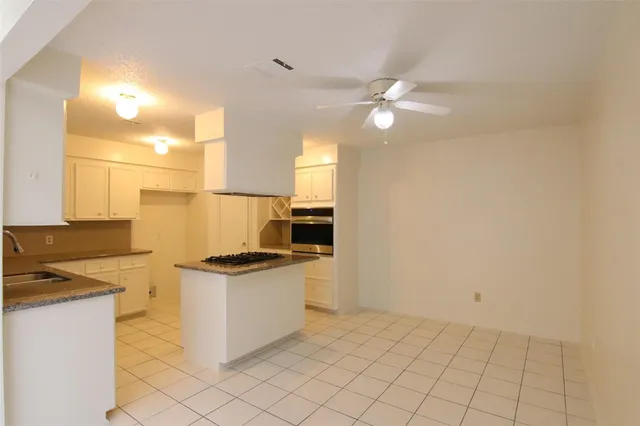 a kitchen with granite countertop white cabinets and stainless steel appliances