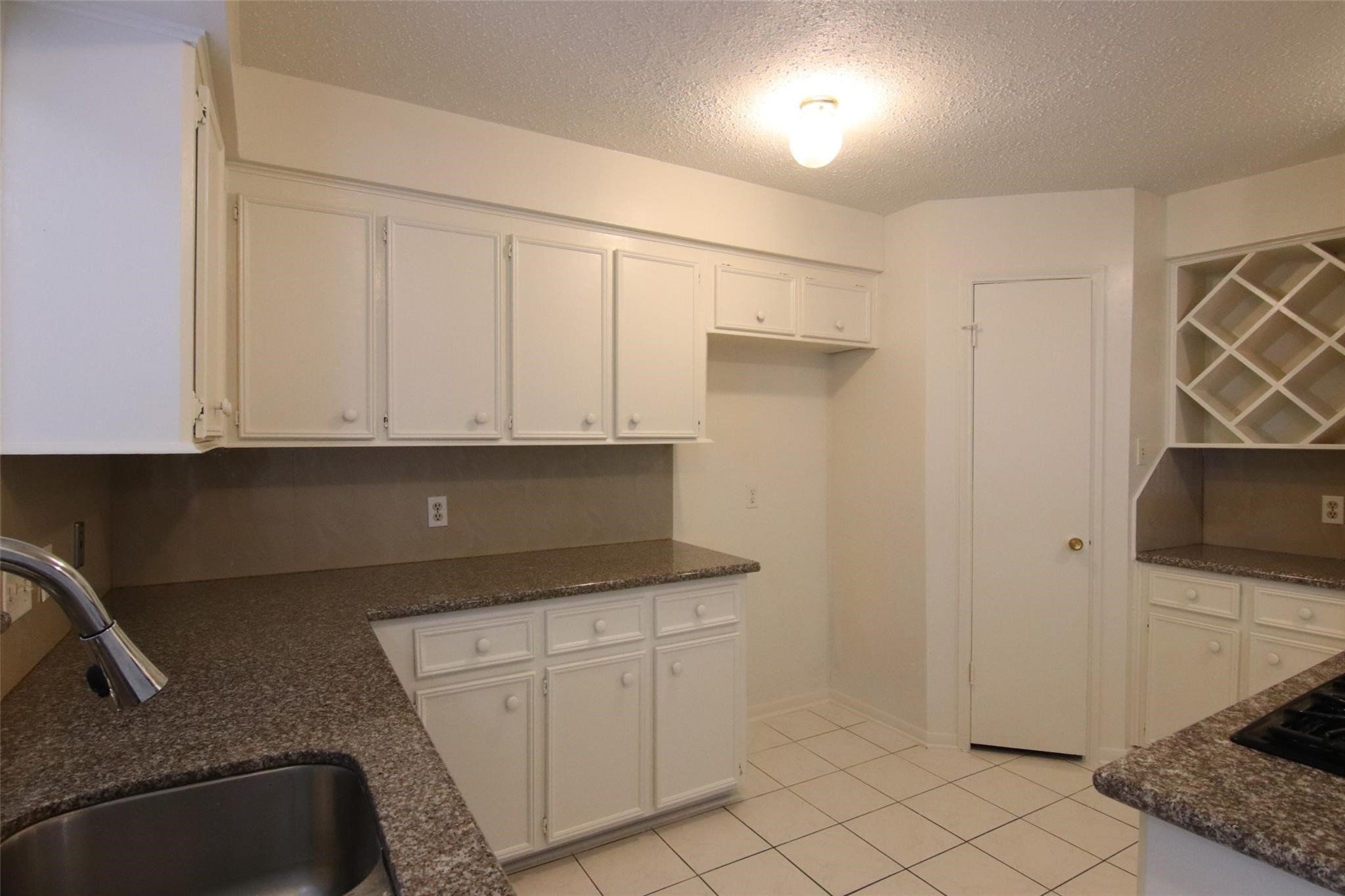 4231 Yupon Ridge Drive Houston, TX 77072 - Photo 9 of 18 a kitchen with white cabinets and appliances