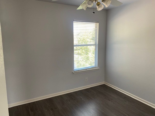 18911 Brownstone Mills Drive Cypress, TX 77433 - Photo 12 of 22 an empty room with wooden floor chandelier fan and windows