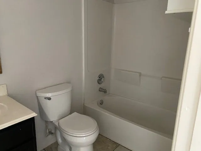 a white toilet sitting next to a bath tub