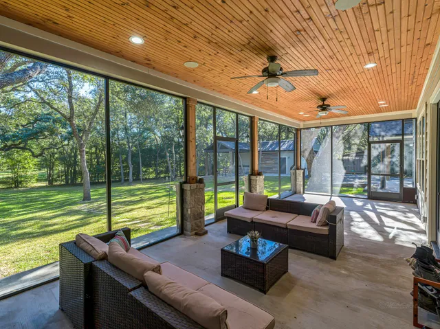 a living room with furniture a flat screen tv and a floor to ceiling window