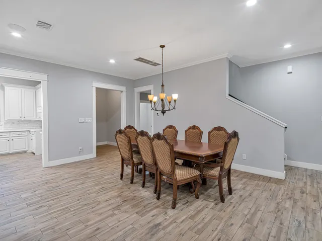 a dining room with furniture a chandelier and wooden floor