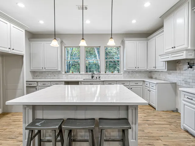 a kitchen with a table chairs sink and cabinets