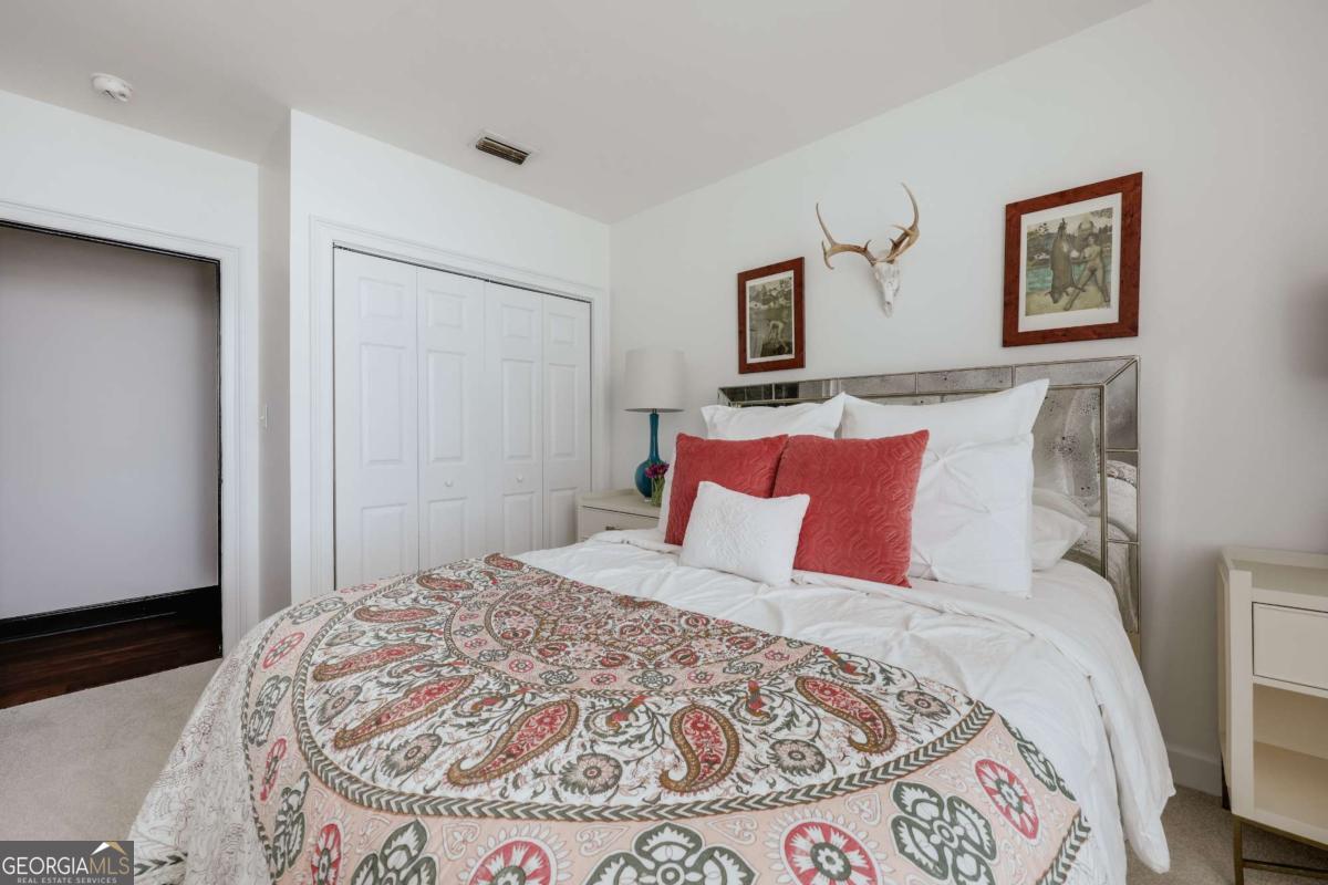 247 West Washington Street, Unit 504 Athens, GA 30601 - Photo 16 of 34 a bedroom with a large bed and a wooden floor