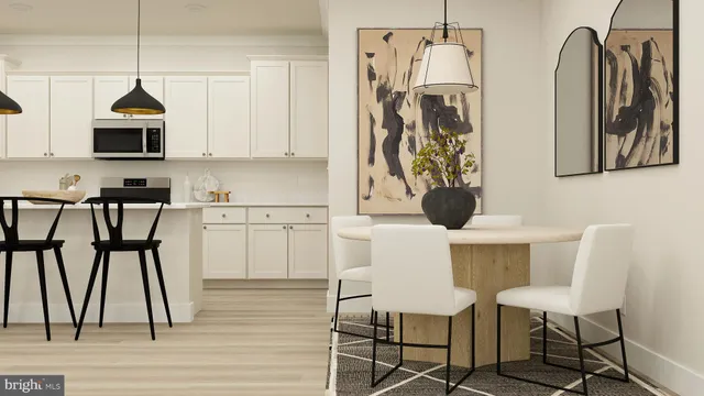 a kitchen with stainless steel appliances a dining table chairs and a refrigerator