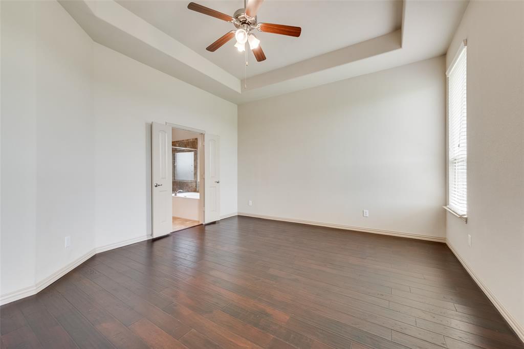 9641 Calaveras Road Fort Worth, TX 76177 - Photo 11 of 23 an empty room with wooden floor chandelier fan and windows