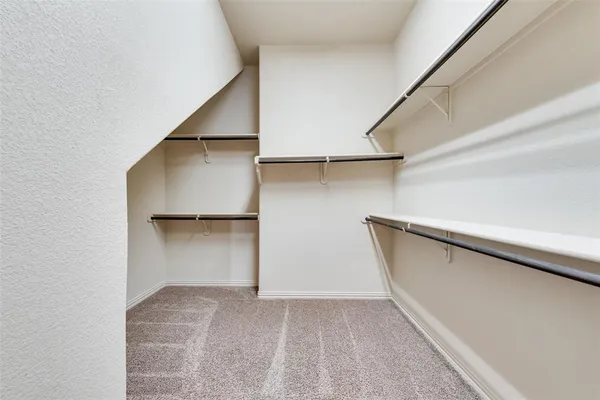 a view of walk in closet with empty racks