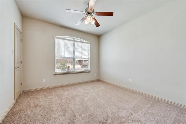 an empty room with windows and fan