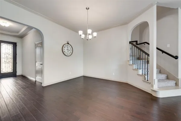 a view of an empty room with wooden floor and windows