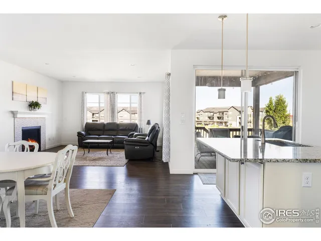 a living room with a table chairs and a view of kitchen