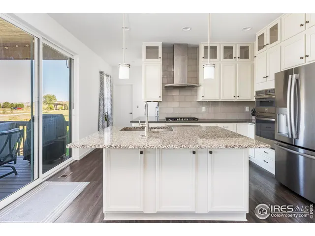 a kitchen with stainless steel appliances granite countertop a refrigerator and a stove