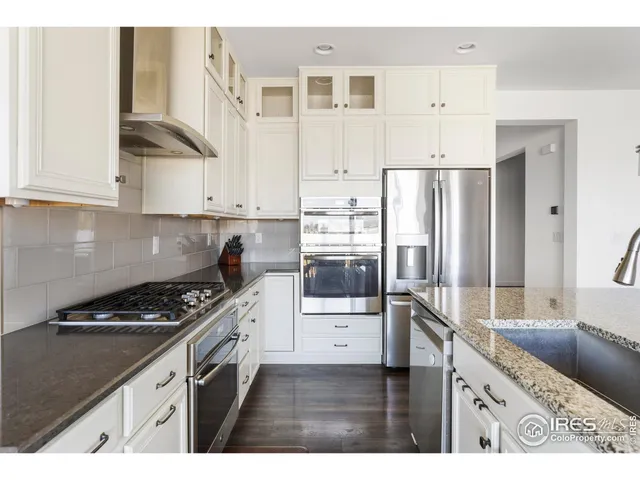 a kitchen with stainless steel appliances granite countertop a refrigerator and a stove