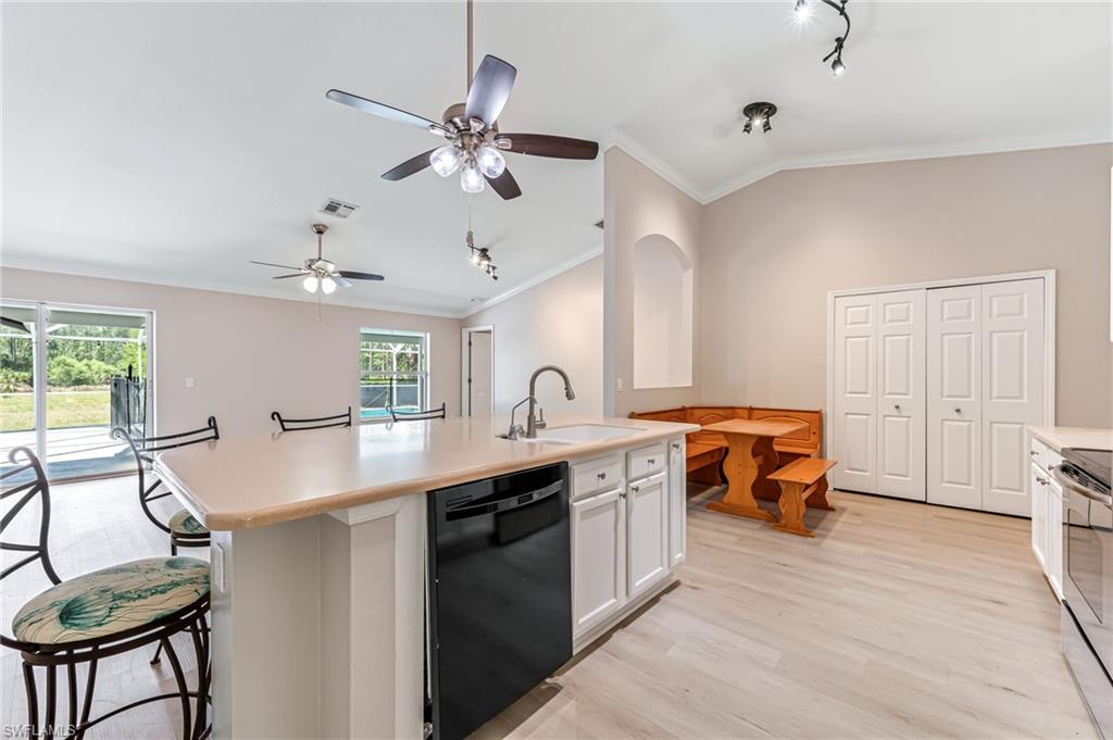 3630 10th Avenue Southeast Naples, FL 34117 - Photo 13 of 50 a view of a kitchen with kitchen island a sink stainless steel appliances and furniture