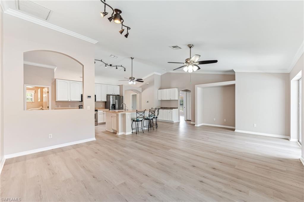 3630 10th Avenue Southeast Naples, FL 34117 - Photo 20 of 50 a view of a living room and kitchen with furniture wooden floor and chandelier