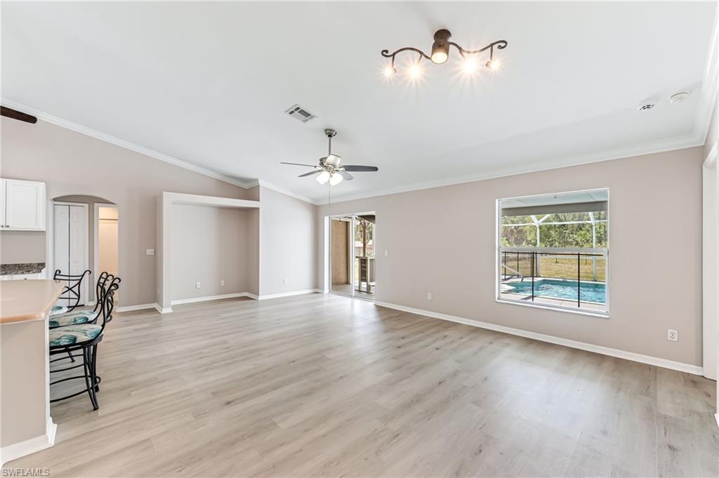 3630 10th Avenue Southeast Naples, FL 34117 - Photo 21 of 50 a view of an empty room with a window and wooden floor