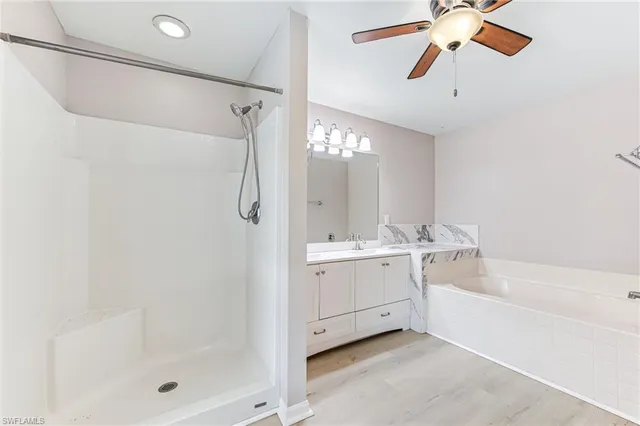 a bathroom with a bathtub a shower a sink and a mirror