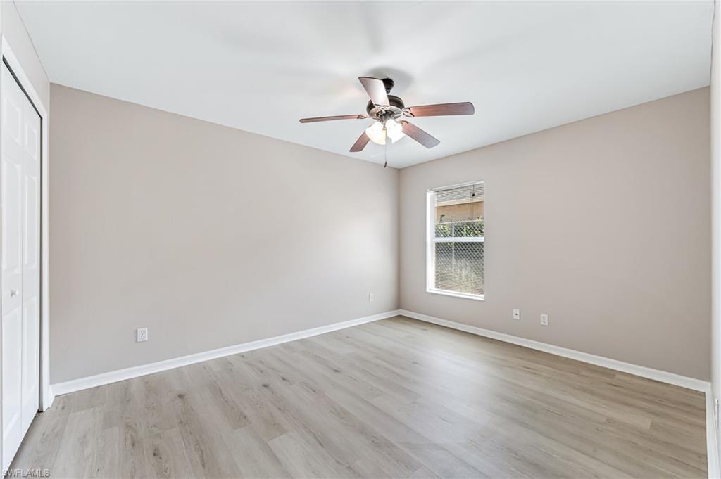 3630 10th Avenue Southeast Naples, FL 34117 - Photo 30 of 50 an empty room with wooden floor fan and windows