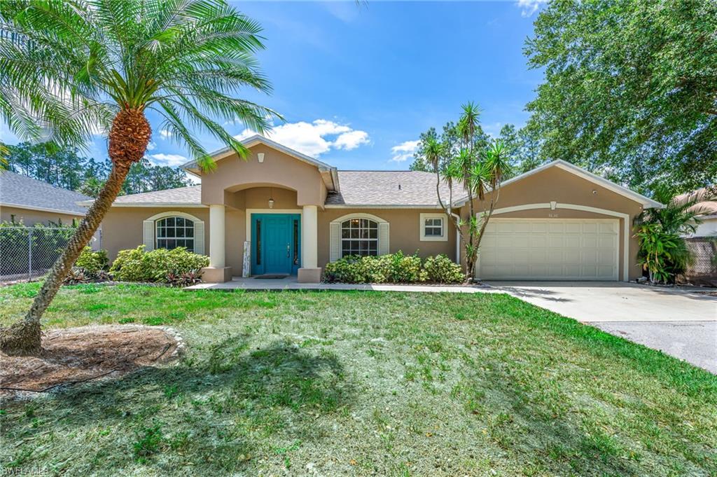 3630 10th Avenue Southeast Naples, FL 34117 - Photo 3 of 50 a front view of a house with a yard and garage